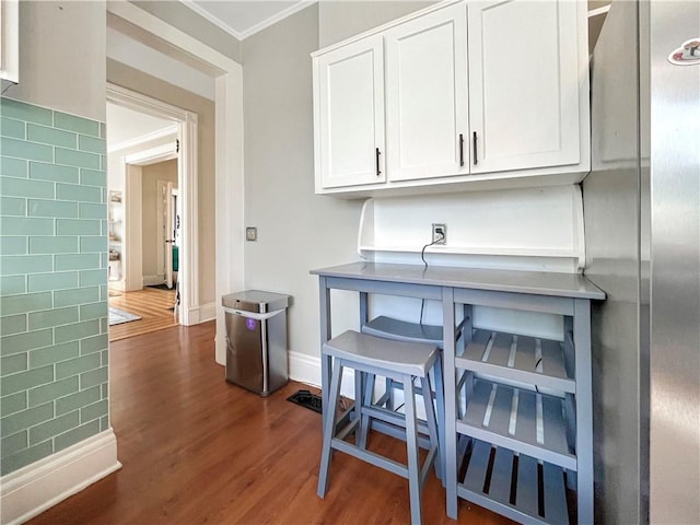 kitchen featuring baseboards, dark wood finished floors, white cabinets, and ornamental molding