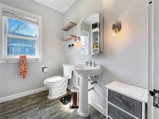 half bathroom featuring toilet, baseboards, and wood finished floors