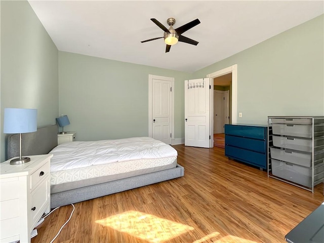 bedroom with light wood-type flooring, baseboards, and ceiling fan