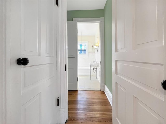 hall with baseboards and wood finished floors