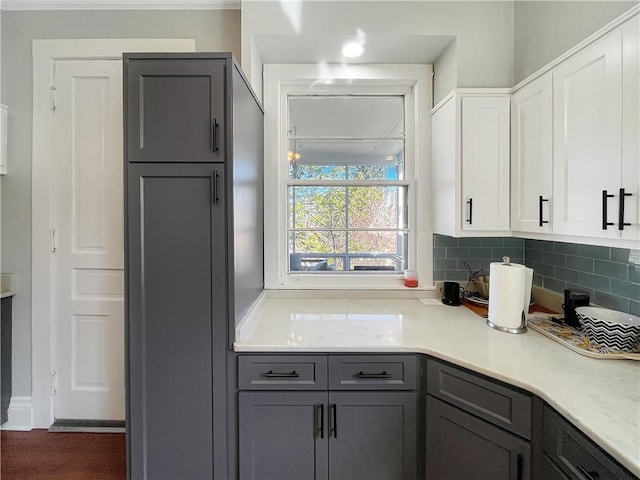 kitchen with decorative backsplash, gray cabinetry, white cabinetry, and light countertops