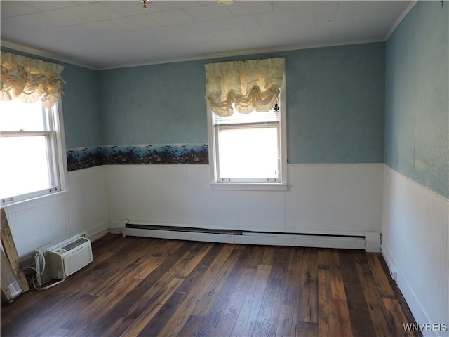 unfurnished room featuring crown molding, wood-type flooring, a wainscoted wall, and baseboard heating