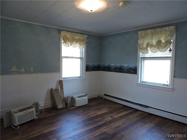 spare room featuring a wall mounted air conditioner, a wainscoted wall, wood finished floors, crown molding, and baseboard heating