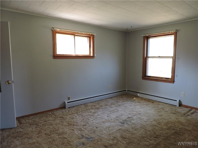 carpeted spare room with crown molding, a baseboard heating unit, and baseboards