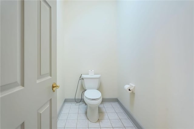 bathroom featuring tile patterned floors, toilet, and baseboards