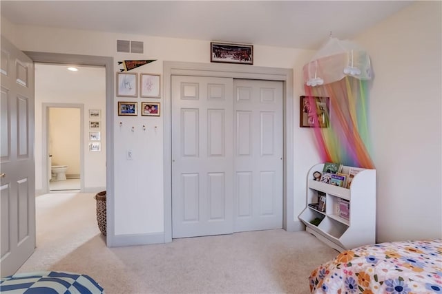 bedroom with visible vents, a closet, and carpet flooring