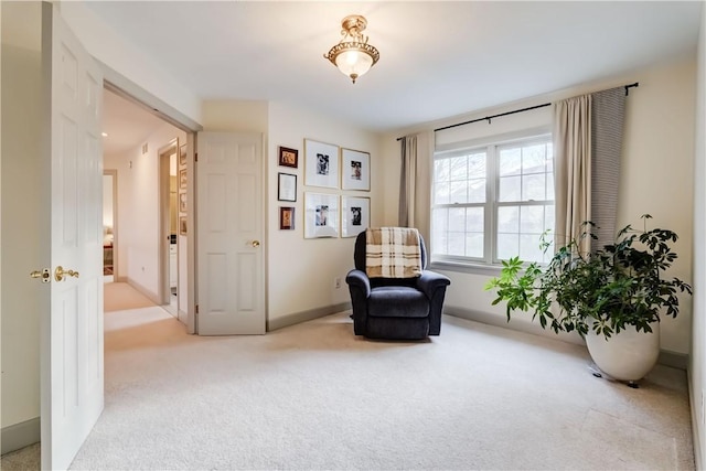 living area with baseboards and carpet