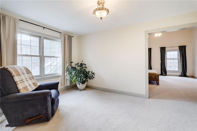 living area with baseboards and carpet