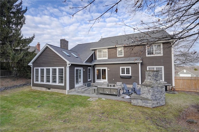 rear view of house featuring entry steps, fence, a yard, a chimney, and a patio area