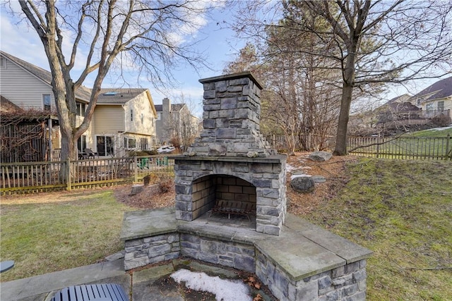 view of patio with an outdoor stone fireplace and fence