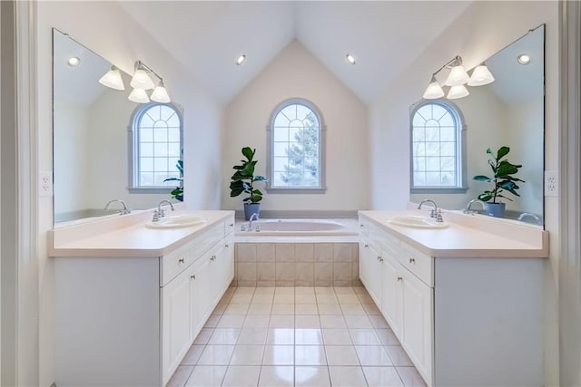 bathroom featuring vaulted ceiling, two vanities, and a sink