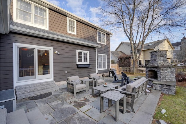 view of patio featuring fence, entry steps, and an outdoor living space with a fireplace