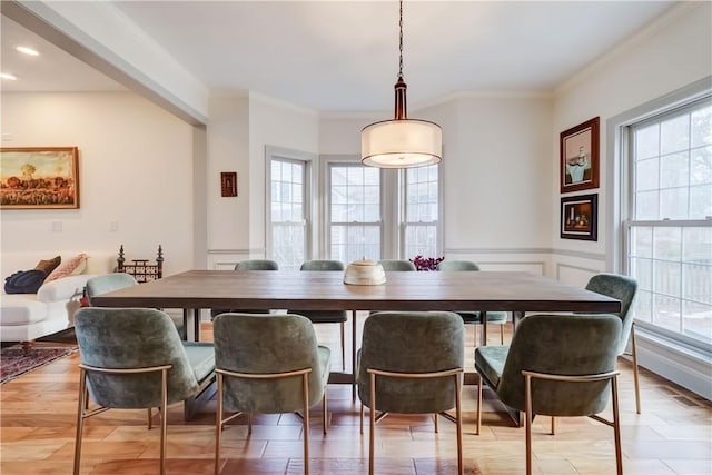 dining area with plenty of natural light, light wood-style flooring, and ornamental molding