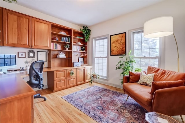 office featuring built in desk and light wood-style floors