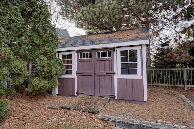 view of shed featuring fence