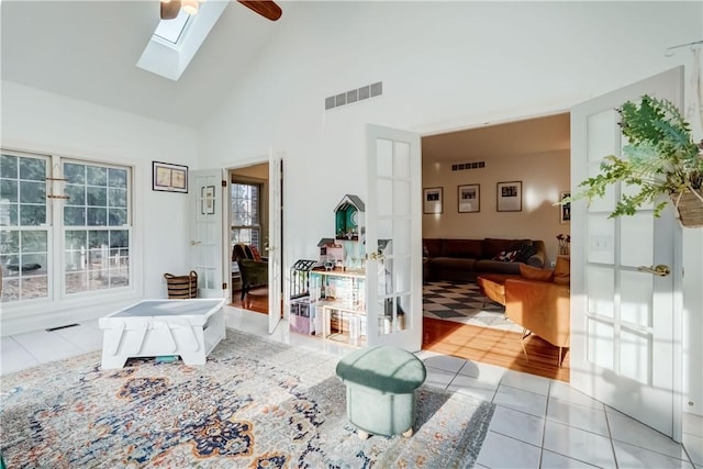 interior space with visible vents, high vaulted ceiling, and a skylight