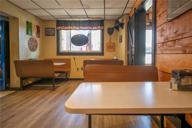 dining room featuring wood finished floors and a paneled ceiling