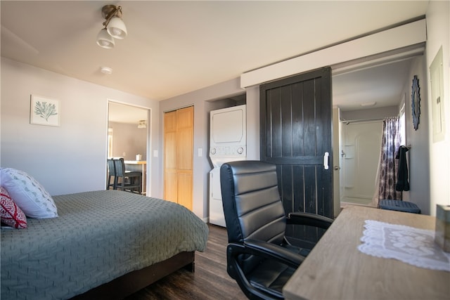 bedroom featuring stacked washer and clothes dryer and dark wood-type flooring