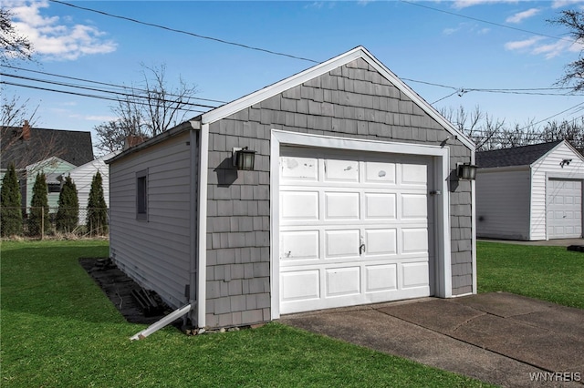 detached garage featuring fence and driveway