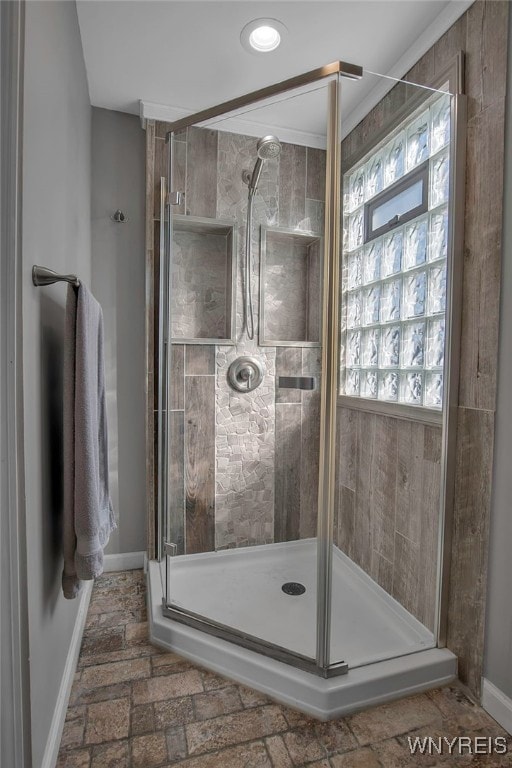 full bathroom with a shower stall and baseboards