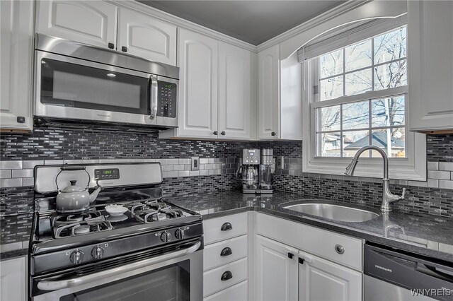 kitchen with a sink, appliances with stainless steel finishes, and white cabinetry