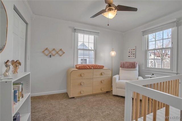 carpeted bedroom featuring baseboards, multiple windows, ceiling fan, and crown molding