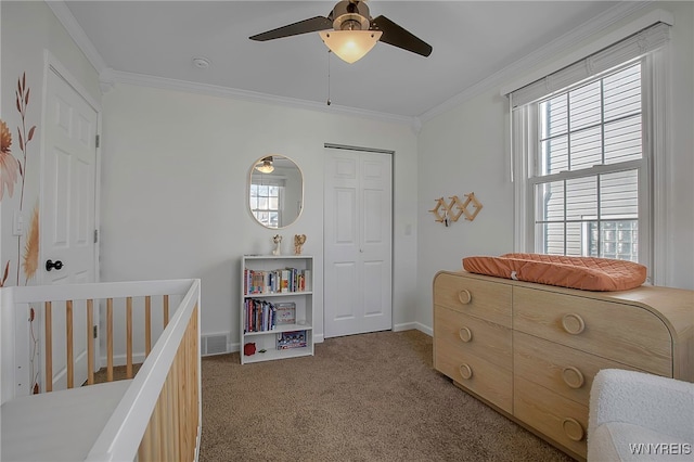 carpeted bedroom with visible vents, ceiling fan, baseboards, ornamental molding, and a closet