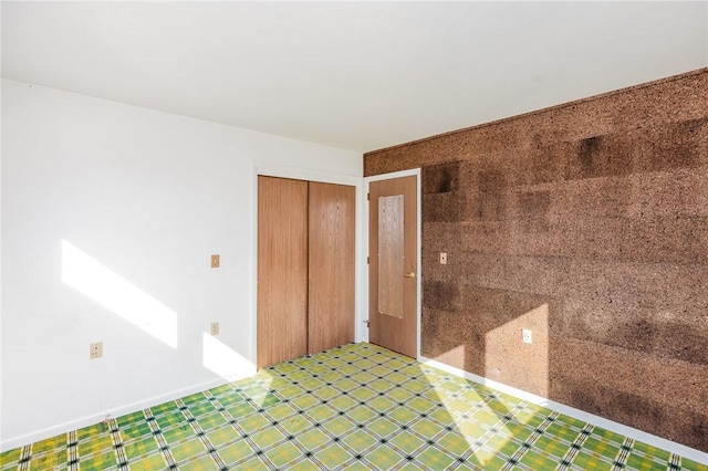 interior space featuring tile patterned floors, a closet, and baseboards