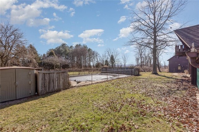 view of yard with a storage unit, an outdoor structure, and fence