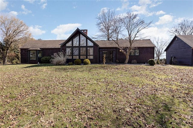 view of front facade featuring a front yard and a chimney