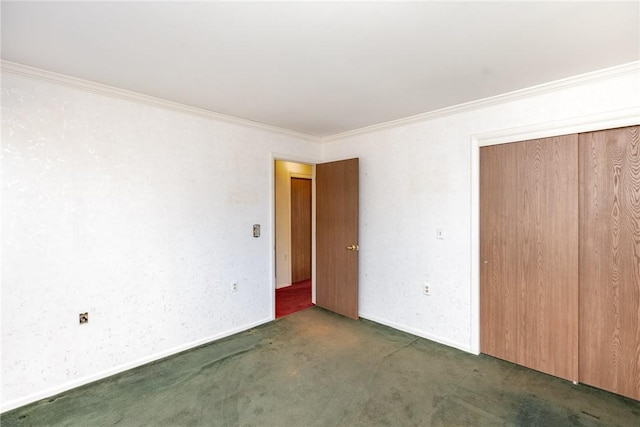 unfurnished bedroom featuring crown molding, baseboards, a closet, and carpet floors