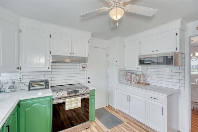 kitchen featuring light wood finished floors, under cabinet range hood, light countertops, appliances with stainless steel finishes, and white cabinetry