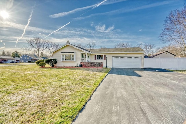 single story home featuring driveway, a front lawn, a garage, and fence