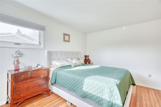 bedroom with light wood-type flooring and baseboards