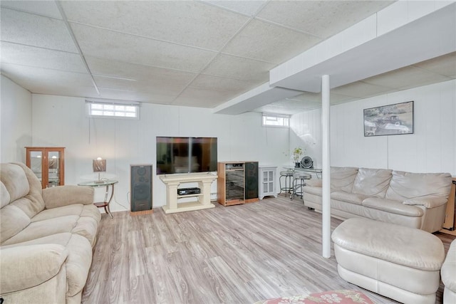 living room featuring beverage cooler, a paneled ceiling, and wood finished floors