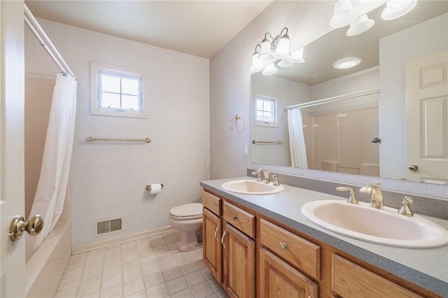 bathroom featuring double vanity, visible vents, toilet, and a sink