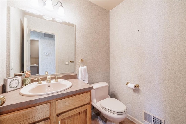 half bath featuring visible vents, toilet, vanity, and wallpapered walls