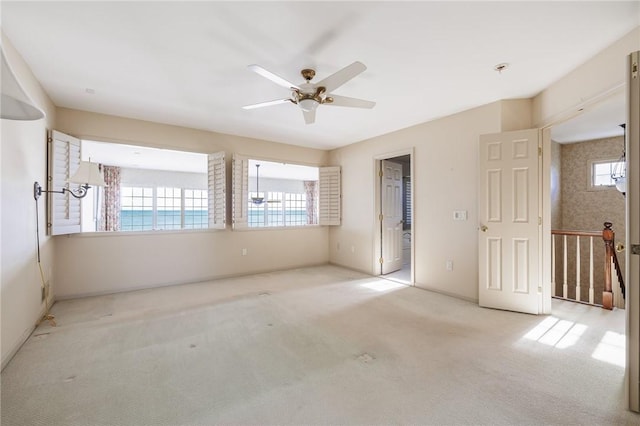 carpeted spare room with a healthy amount of sunlight and ceiling fan