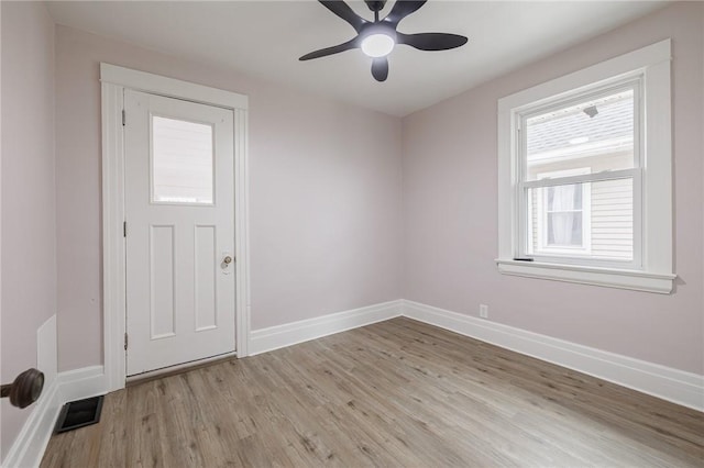 interior space featuring ceiling fan, light wood-style floors, visible vents, and baseboards