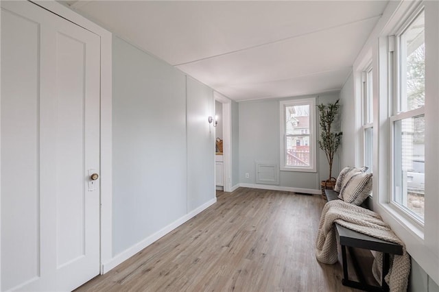 living area featuring baseboards and light wood finished floors