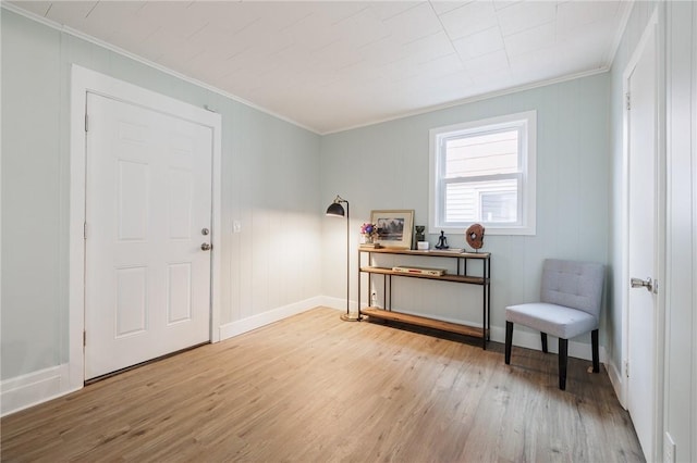 sitting room featuring light wood finished floors, baseboards, and ornamental molding