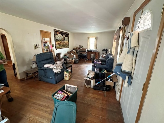 living room with arched walkways and wood finished floors