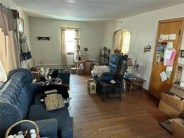 living room featuring arched walkways and wood finished floors