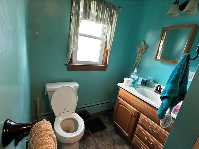 half bath with vanity, toilet, and a baseboard heating unit