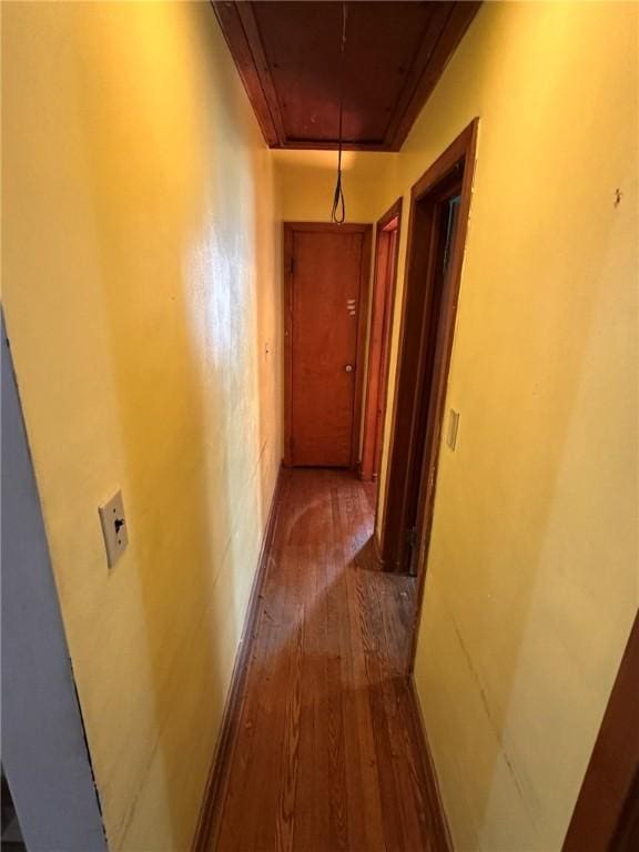 corridor featuring dark wood-style floors and attic access