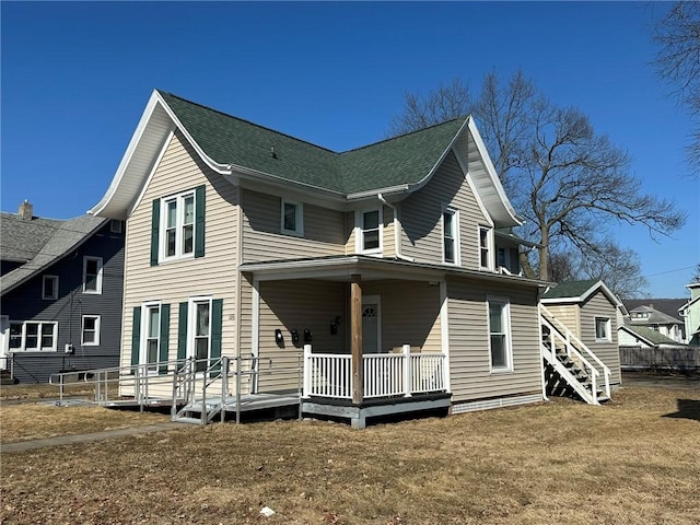 back of house with a porch and roof with shingles