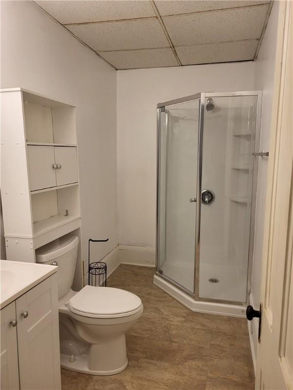 full bath with a drop ceiling, toilet, a stall shower, and vanity