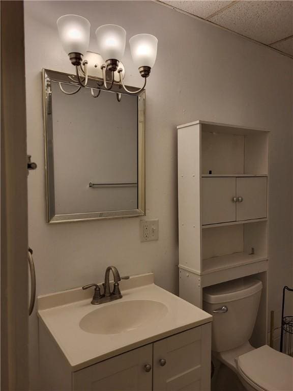 bathroom featuring vanity, toilet, and a paneled ceiling