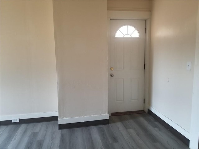 foyer entrance featuring baseboards and wood finished floors