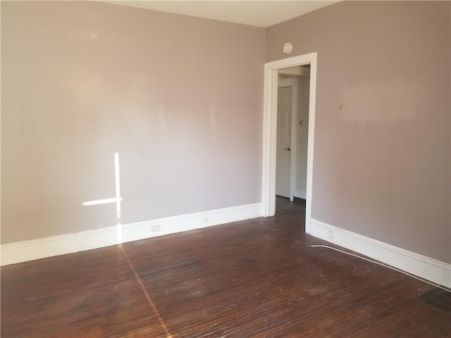 empty room with baseboards and wood finished floors